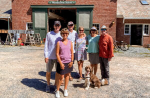 People posing in from of a barn