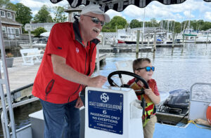 A little boy driving a boat