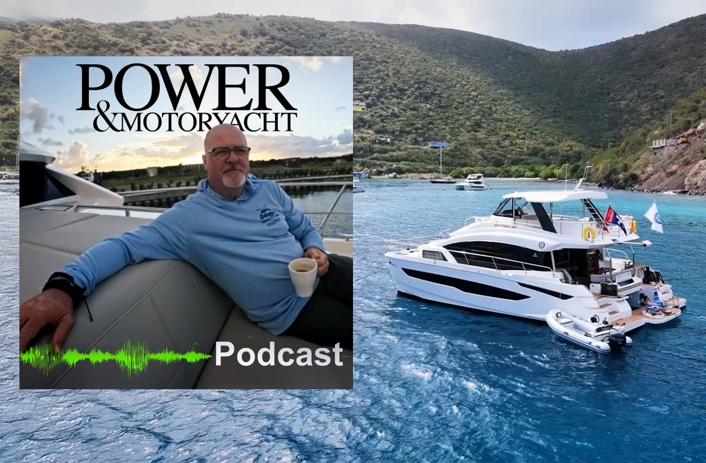 feat-Wandering-Hillbilly A promotional cover image for the Power & Motoryacht Podcast. The main background shows a sleek, multi-deck white power catamaran anchored in vibrant turquoise Caribbean water near a lush, green, mountainous island coastline under an overcast sky. A small white rigid inflatable boat (RIB) tender is tied up along its broad aft swim platform. Inset on the left is a square portrait of a man with glasses and a goatee wearing a light blue hoodie, relaxing on a yacht's grey exterior cushions while holding a white coffee mug. The top of the inset features the black "POWER & MOTORYACHT" logo, while a green audio soundwave graphic and the white text "Podcast" sit at the bottom.