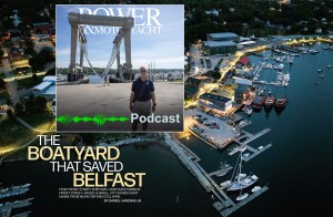An aerial, high-angle twilight view of a bustling waterfront shipyard and marina with a prominent article title overlay reading "THE BOATYARD THAT SAVED BELFAST." In the top left corner, a rectangular inset displays a Power & Motoryacht podcast graphic showing a man standing in front of a massive "FRONT STREET SHIPYARD" mobile boat hoist, complete with a green audio waveform and the word "Podcast." The background shows the illuminated Safe Harbor Front Street Shipyard facility in Belfast, Maine, with docks, service buildings, and boats floating in the calm water.