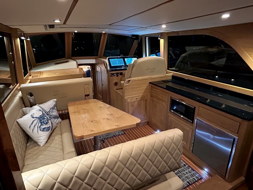 The interior features a high-end, New England-style Down East yacht salon and helm area, highlighted by fine joinery, custom upholstery, and modern navigation electronics.