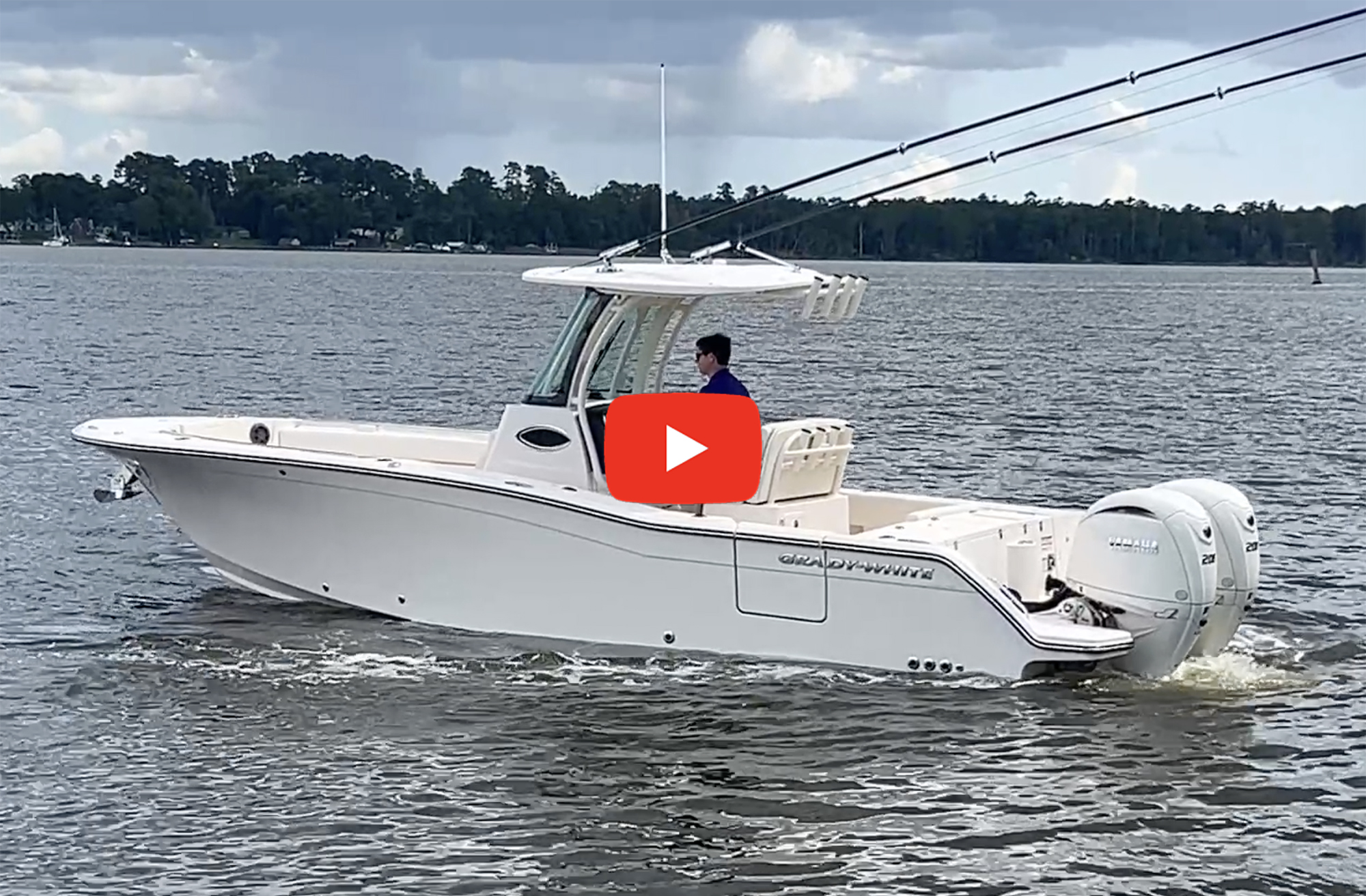 A white Grady-White Canyon 266 center-console boat powered by twin Yamaha outboards underway on calm water, with a red YouTube play button overlay on the image.
