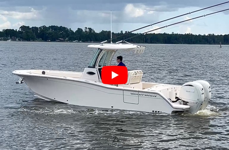 A white Grady-White Canyon 266 center-console boat powered by twin Yamaha outboards underway on calm water, with a red YouTube play button overlay on the image.
