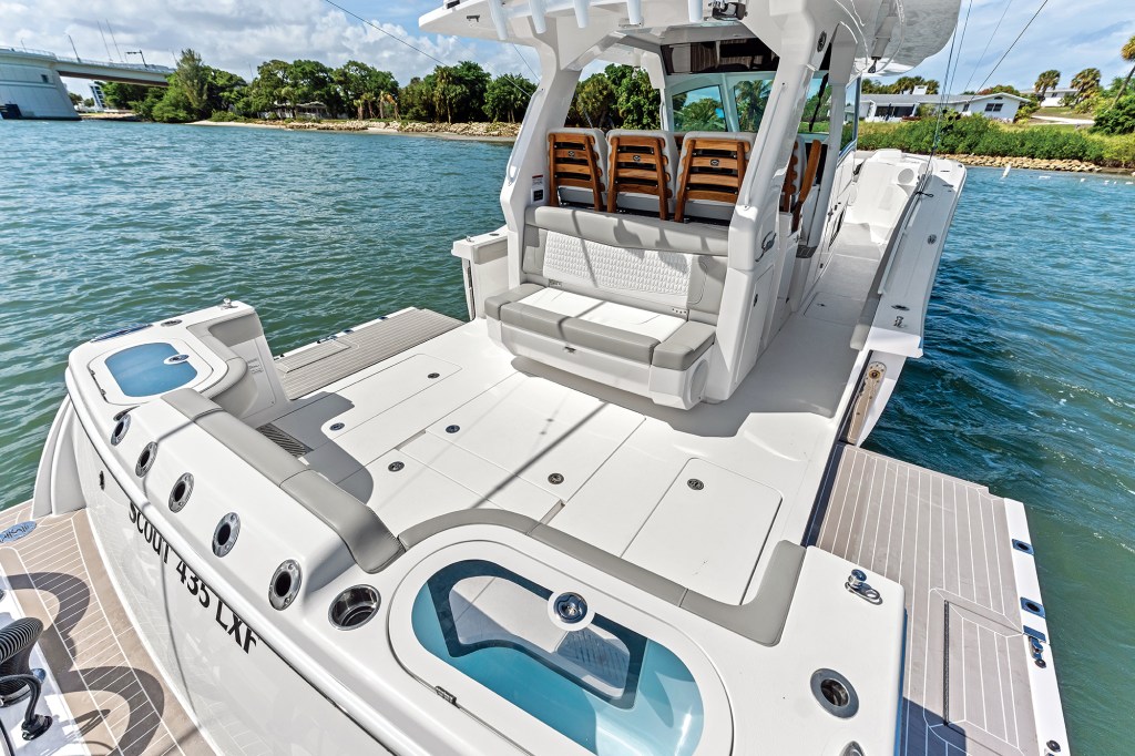 Spacious cockpit and fold-down beach platforms of the Scout 435 LXF center console boat featuring livewells, rod holders, and seating.