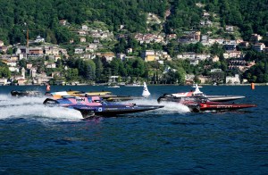 Electric RaceBird boats competing in the UIM E1 World Championship on Lake Como against a scenic hillside backdrop.