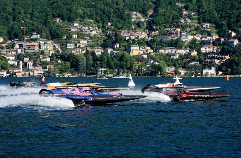 Electric RaceBird boats competing in the UIM E1 World Championship on Lake Como against a scenic hillside backdrop.
