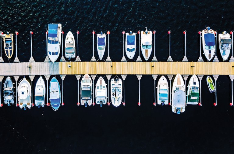 Aerial view of boats, yachts, water bike and wooden sauna in a m Aerial view of boats, yachts, water bike and wooden sauna in a marina in summer Finland