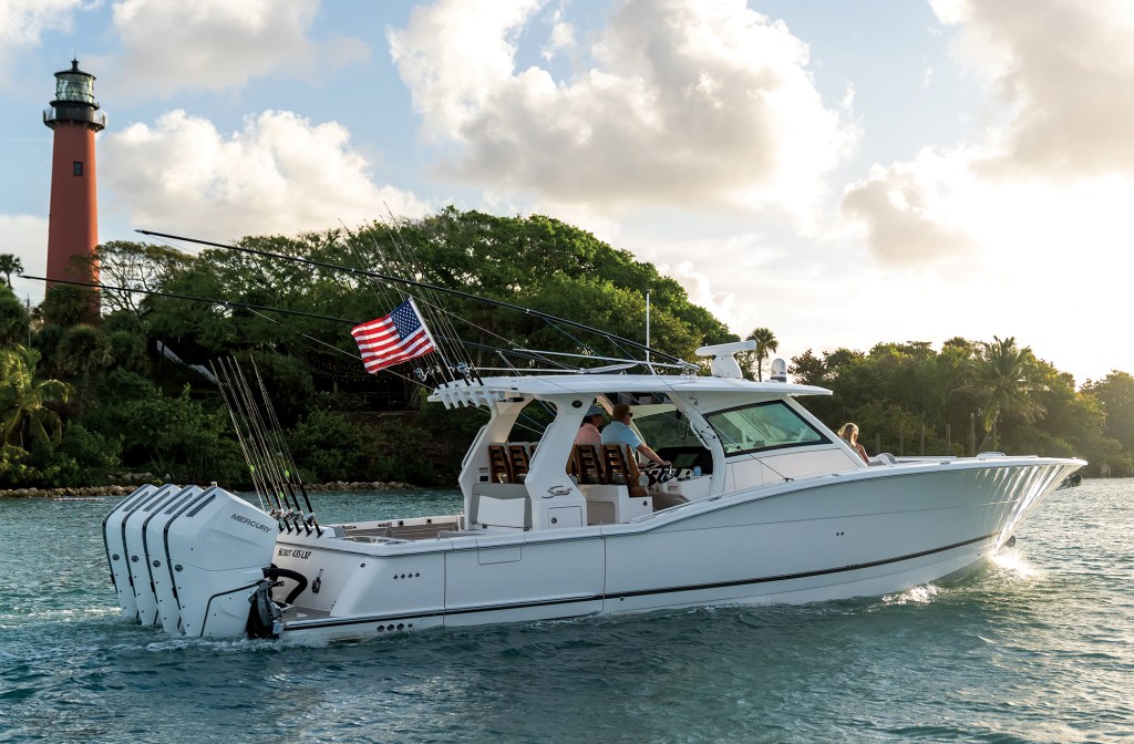 feat_Scout 435LXF Li-Ion White Scout 435 LXF luxury center console boat with quad outboard Mercury engines cruising past Jupiter Inlet Lighthouse.
