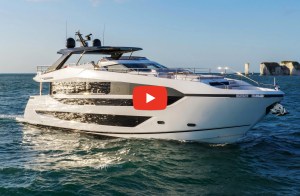 Sunseeker Manhattan motor yacht cruising through open blue water on a sunny day with a video play icon overlaid.