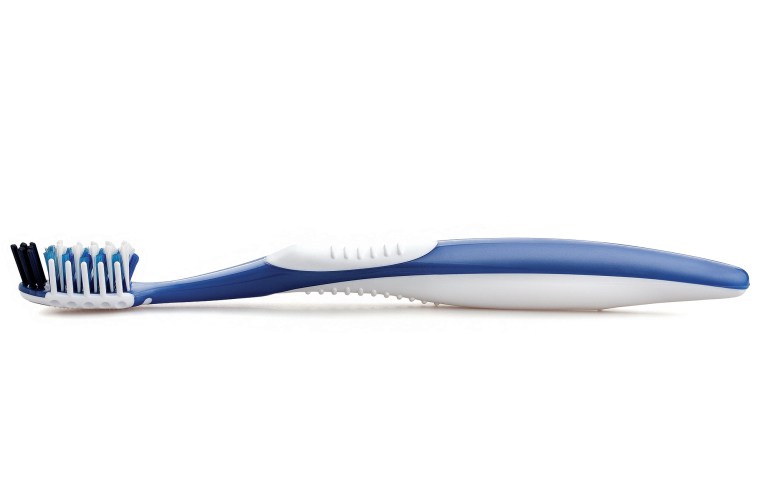 A side-profile studio photo of a blue and white manual toothbrush isolated on a plain white background.