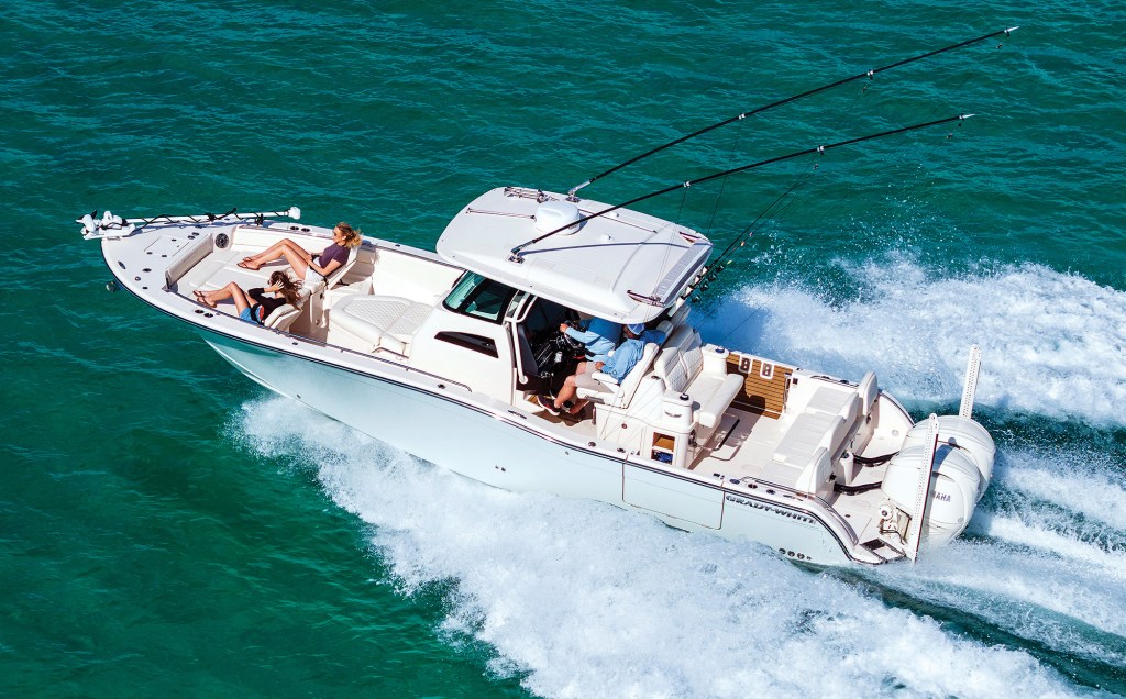 Aerial view of a Grady-White 321 CE center console boat cruising through open water with passengers relaxing in the bow lounges.