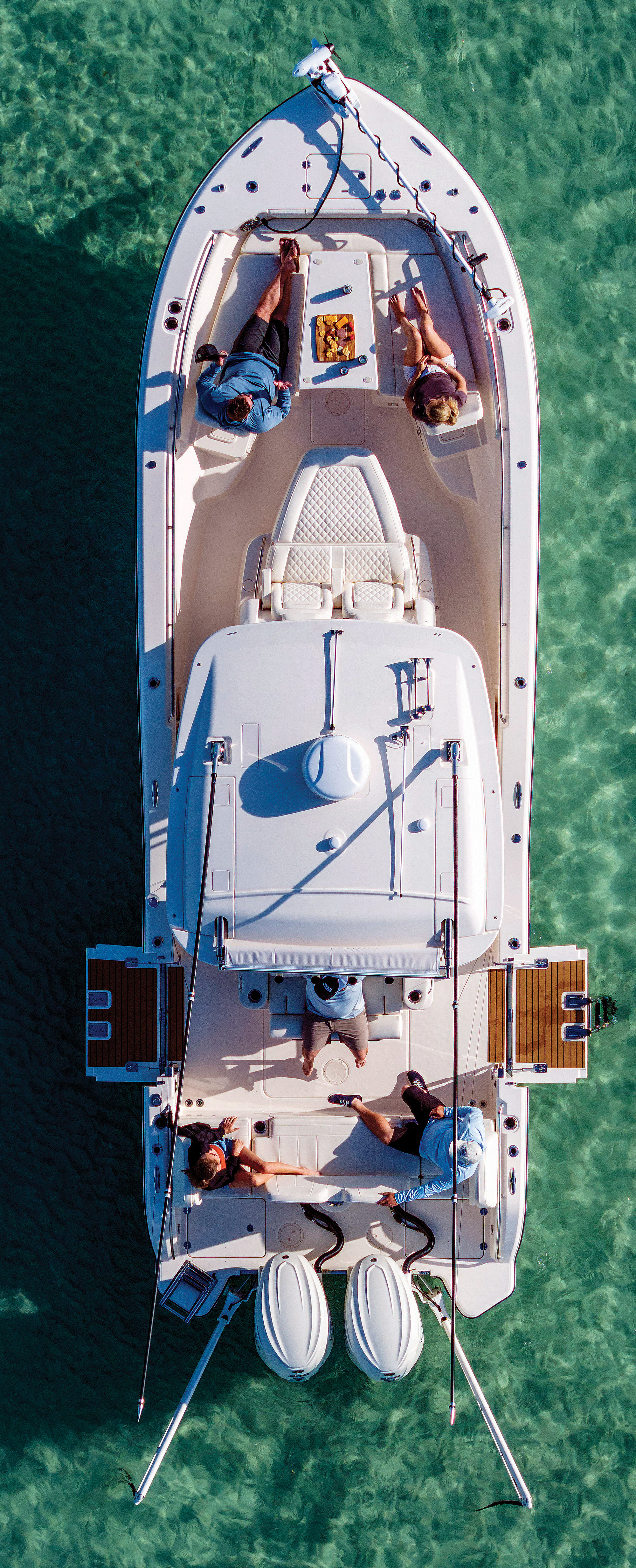 Direct overhead aerial view of a Grady-White 321 CE with its dual gunwale dive doors lowered anchored in shallow turquoise water.